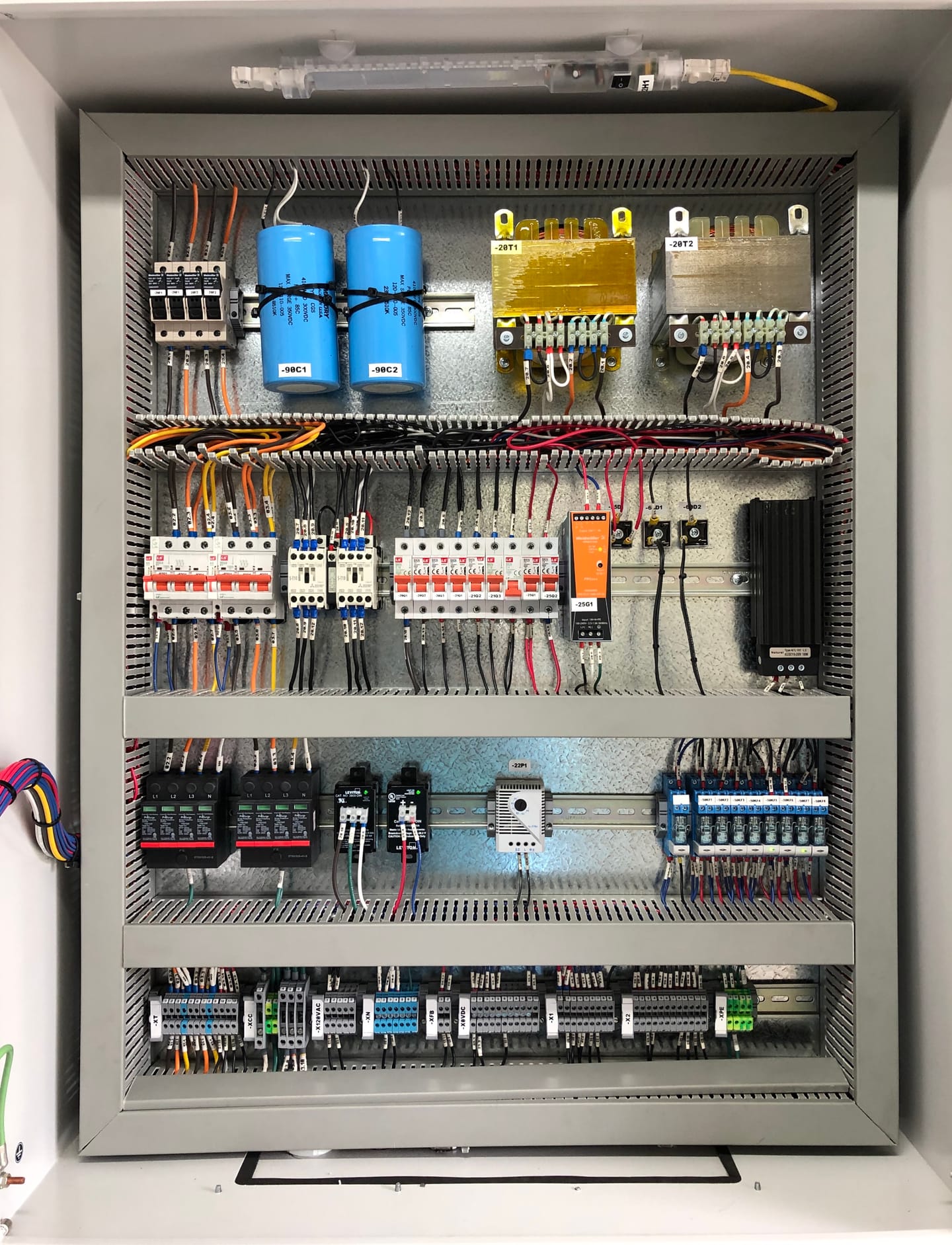 Interior de un tablero de control con protecciones, relés y cableado marcado.