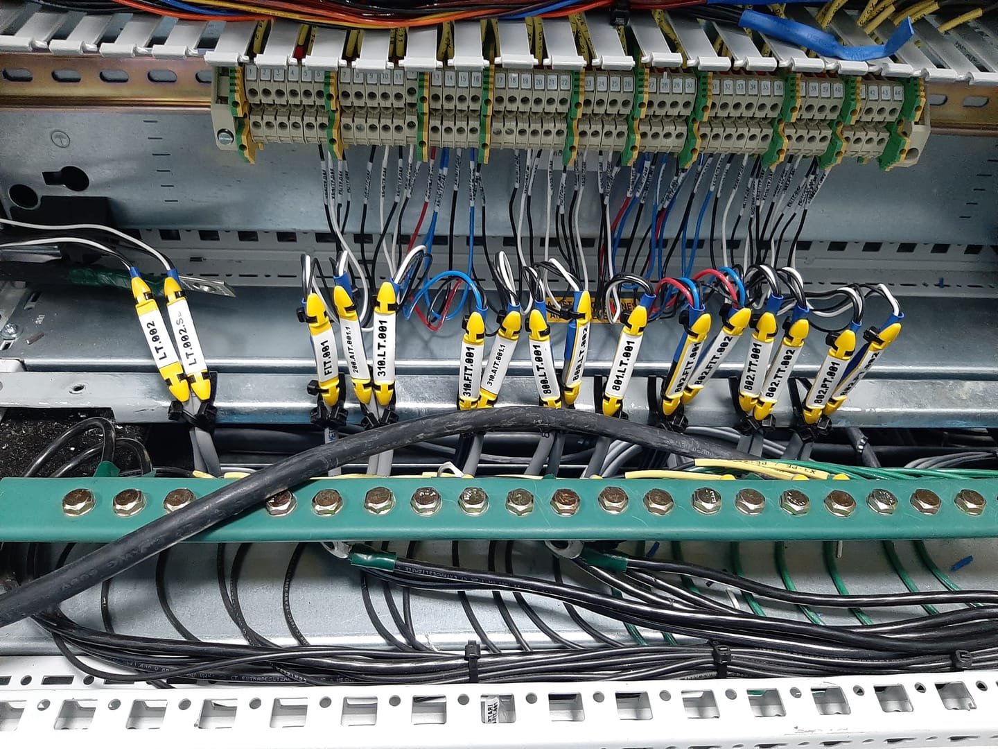 Cableado y borneras con marquillas de identificación sobre barraje de puesta a tierra.